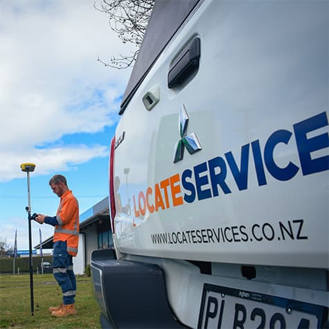 GPS Technician prepares to survey as he stands near a Locate Services vehicle.