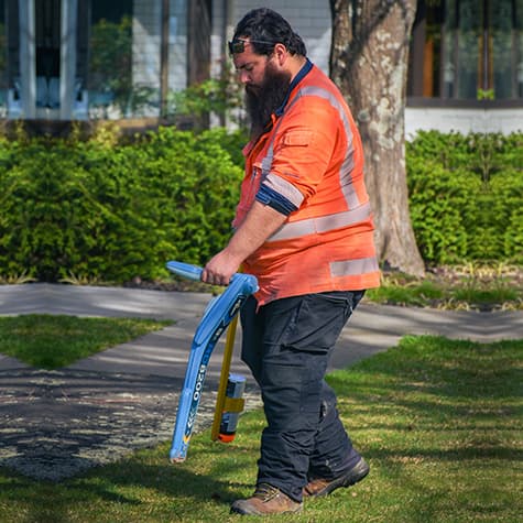 Technician uses a locating device to locate underground utilities